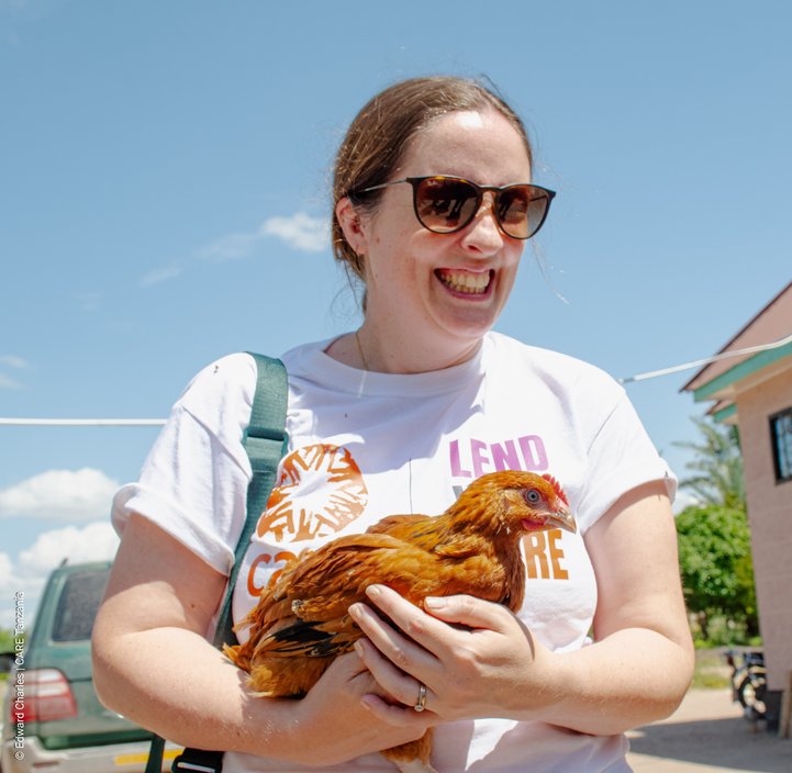 A woman in a CARE T Shirt holding a chicken