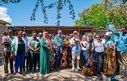 A group of about 30 men and women pose together outside for a photograph