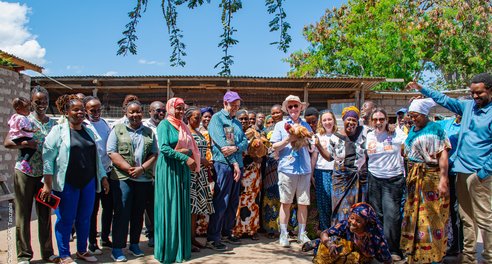 A group of about 30 men and women pose together outside for a photograph