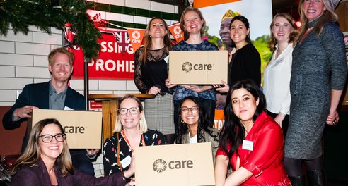 A group of CIUK staff pose with a CARE package at CARE's 80th anniversary event