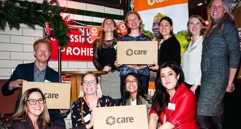 A group of CIUK staff pose with a CARE package at CARE's 80th anniversary event