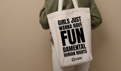A person carrying a tote bag with the slogan 'Girls just wanna have FUNdamental human rights' plus the CARE logo