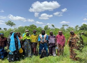 A group of about 10 women gathered in a field