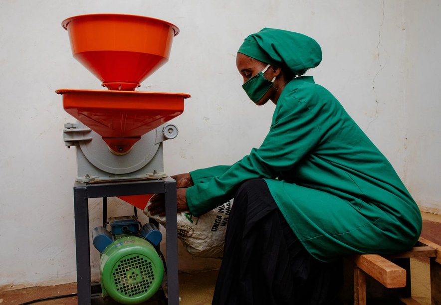 A woman using a spice grinding machine