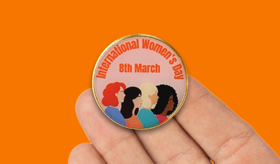A badge with the words International Women's Day 8th March and a graphic of four women