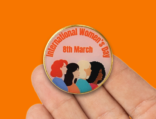 A badge with the words International Women's Day 8th March and a graphic of four women