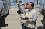 Two humanitarian workers stand by an aid trucker looking at its contents