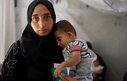 A mother holds a baby close to her chest