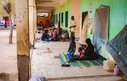 Groups of women and children sit on the floor together in an IDP camp in Port Sudan
