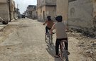 Children cycle through destroyed neighbourhoods in Syria