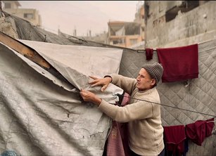 A man makes reparis to a tent