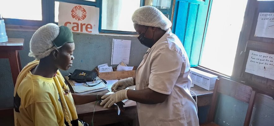 A nurse attends to a patient at a CARE-supported health facility in Bunia, eastern DRC