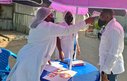 Two healthcare workers in masks conduct temperature checks