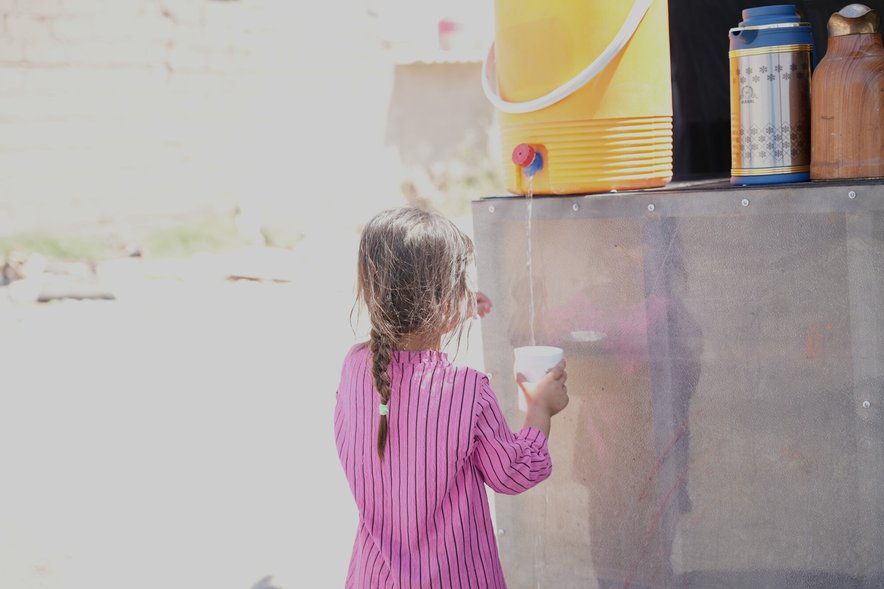 A child getting water from a water tank