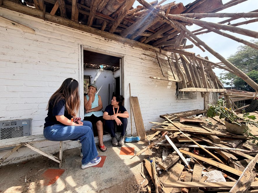 Women sit in rubble amid widespread destruction following an earthquake in western Colombia