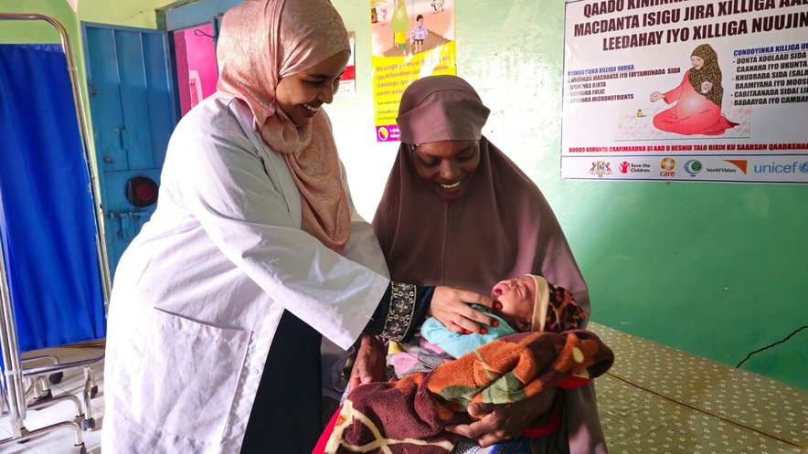 Khadra and her children with a nurse at a CARE health clinic