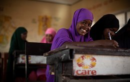 A school girl at her desk - her desk has the CARE logo on it