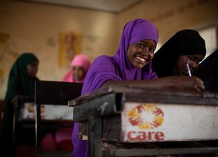 A school girl at her desk - her desk has the CARE logo on it