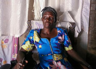 A woman sitting in a chair with materials draped behind her
