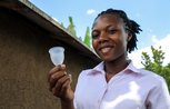 A young woman holding a menstrual cup