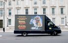 A truck drives in front of a UK parliamentary building with the slogan 'Dear Prime Minister, Back to the Future is a film, not foeign policy Reverse the Rollback. don't take women's rights back by decades. Protect funding for women and girls.
