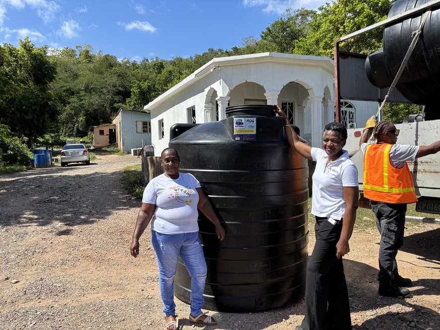 Eveeat Grandison receiving her water tank in Jamaica.