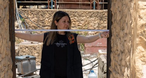 A woman measuring a doorway with a tape measure