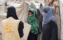 Two Yemeni women talk to a female aid worker wearing a CARE vest