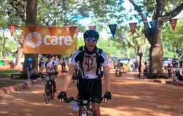 A male cyclist celebrates as he crosses the finish line after completing a fundraising event for CARE.